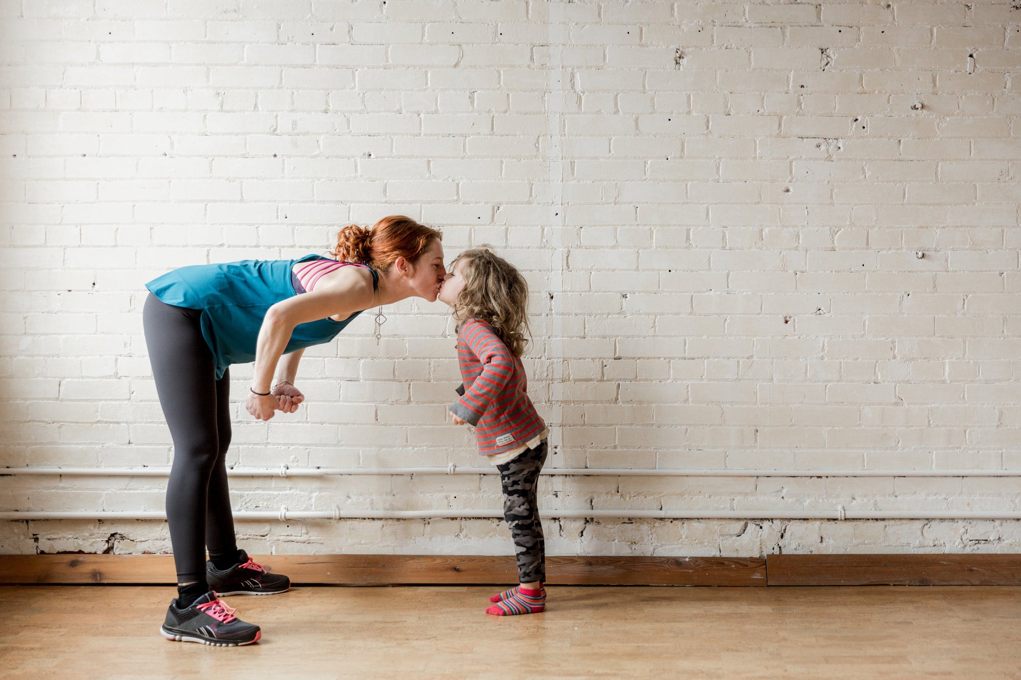 A mother bends down to her daughter's eye level